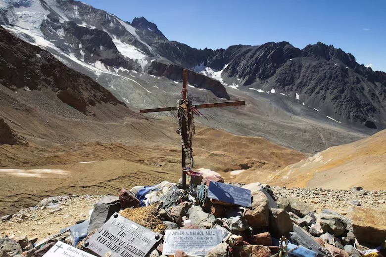 Cruz del Memorial, junto a placas con nombres, flores y objetos de las víctimas